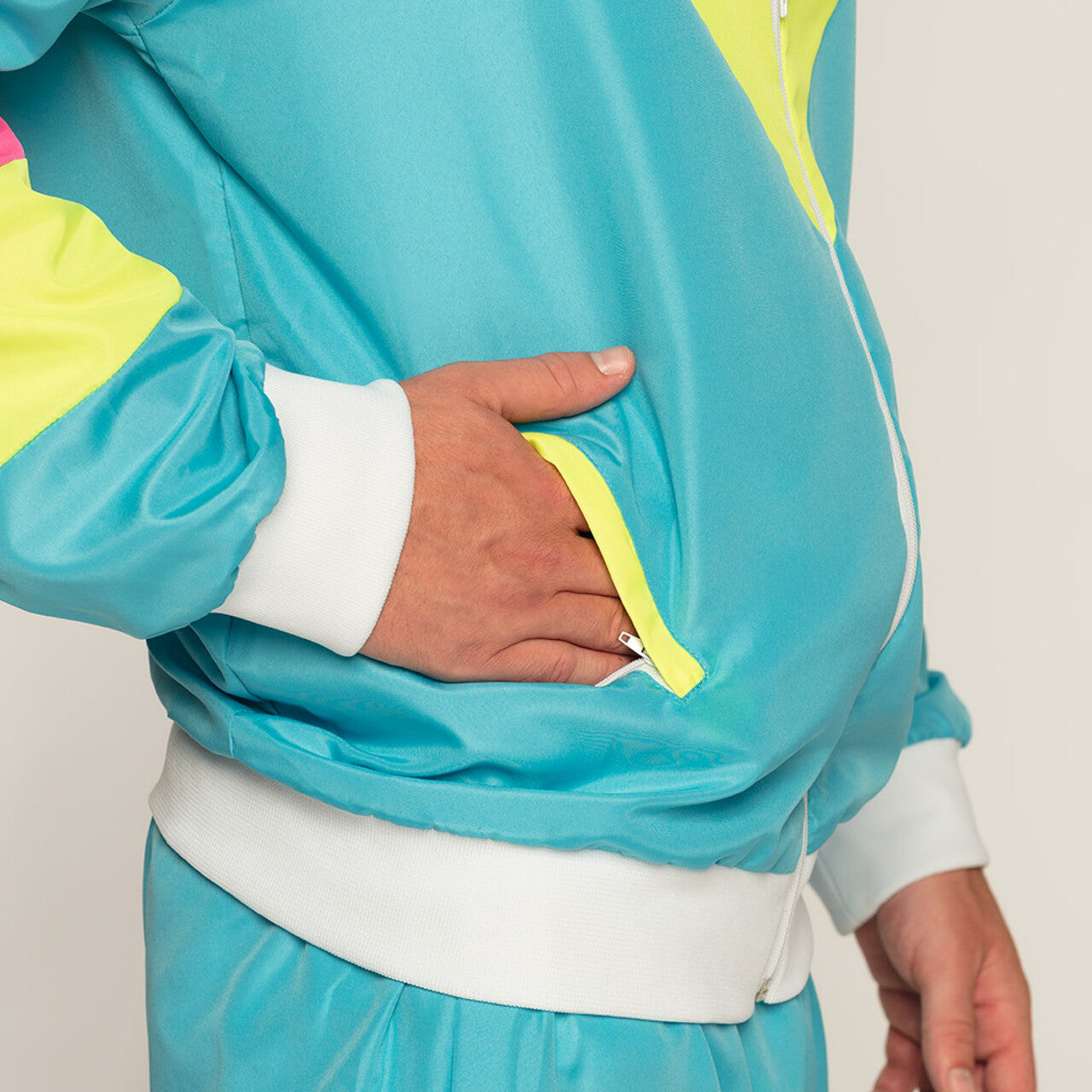 Op deze afbeelding zie je een Kostuums, van het merk Boland. Trainingspak Retro Dude Neonblauw Man Kostuum